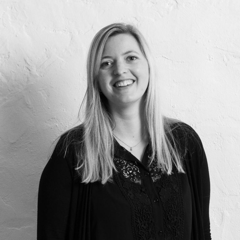 Lächelnde Hilke Mahrt mit langen, blonden Haaren vor einer hellen Wand.