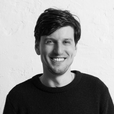 Frederik Iven Frederik Iven mit dunklem Haar, lächelt freundlich vor einer hellen Wand.